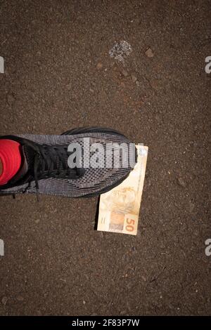 Auf brasilianisches Geld zu treten. Konzept Bild der brasilianischen Wirtschaft. Stockfoto