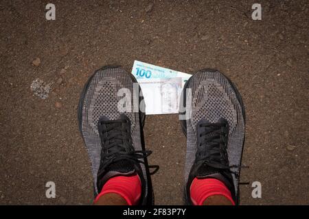 Auf brasilianisches Geld zu treten. Konzept Bild der brasilianischen Wirtschaft. Stockfoto