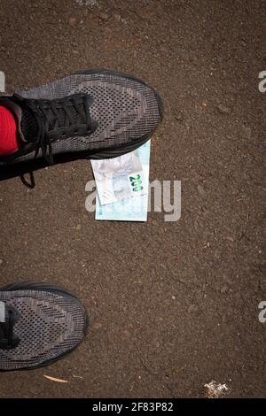 Auf brasilianisches Geld zu treten. Konzept Bild der brasilianischen Wirtschaft. Stockfoto