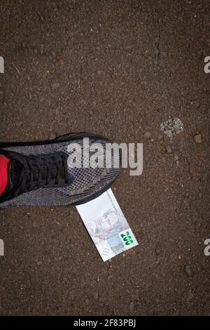 Auf brasilianisches Geld zu treten. Konzept Bild der brasilianischen Wirtschaft. Stockfoto