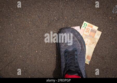 Auf brasilianisches Geld zu treten. Konzept Bild der brasilianischen Wirtschaft. Stockfoto