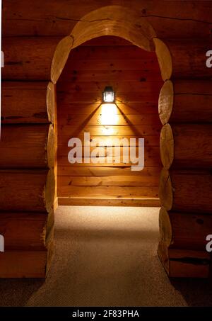 Blick auf einen hölzernen Bogengang und eine Wand montiert Licht im Hintergrund Stockfoto