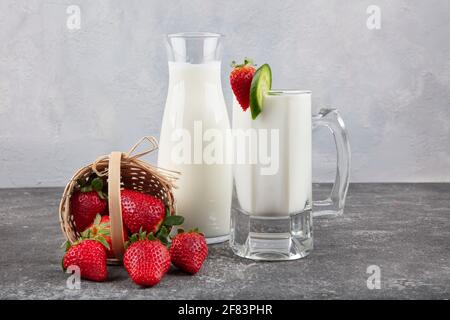 Gesunde Bio trinkbarer Joghurt Kefir in einem Glas. Nahaufnahme eines vollen Glases weißer Kefir, angereichert mit Minzblättern. Stockfoto