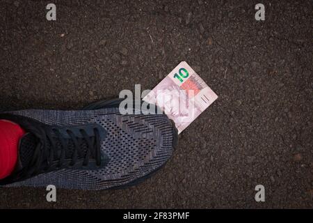 Auf brasilianisches Geld zu treten. Konzept Bild der brasilianischen Wirtschaft. Stockfoto