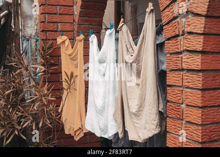 Gewaschene Kleidung, Hemden, die vor dem Haus hängen Stockfoto