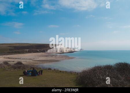 Menschen, die sich im Seaford Head Nature Reserve und am ruhigen Strand von Cuckmere Haven am oberen Rand des Chalk Cliffs Walk ausruhen. Sieben Schwestern, Sout Stockfoto