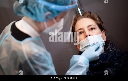 Hamburg, Deutschland. April 2021. Eine Frau wird in einem Corona Rapid Test Center mit einem Nasenabstrich auf Coronavirus getestet. Quelle: Daniel Reinhardt/dpa/Alamy Live News Stockfoto