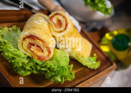 Tomatenrollen Ei Omelette Rezept auf einem Bett mit Salat Stockfoto