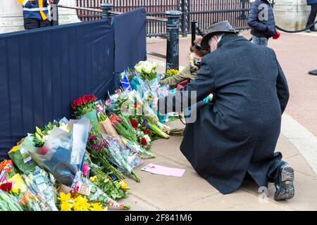 11. April 2021, London, Großbritannien - Menschen, die Blumen zu Ehren von Prinz Philip, Herzog von Edinburgh, vor dem Buckingham Palace nach seinem Tod am 9. April legen Stockfoto