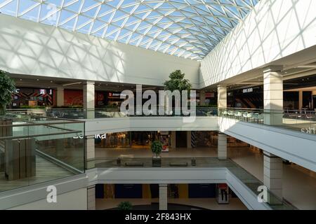 Grodno, Weißrussland - 07. April 2021: Das Innere des modernen großen Einkaufs- und Unterhaltungskomplexes Trinity mit transparentem Glasdach. Stockfoto