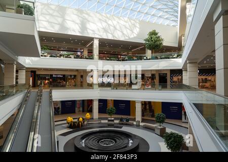 Grodno, Weißrussland - 07. April 2021: Das Innere des modernen großen Einkaufs- und Unterhaltungskomplexes Trinity mit transparentem Glasdach. Stockfoto