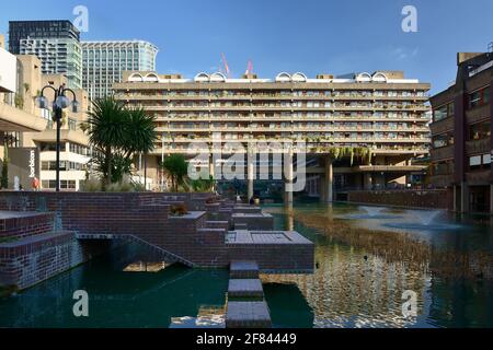 The Barbican Centre, Lakeside Terrace Fountains mit einem der Wohnblöcke des Barbican Estate im Hintergrund, City of London, Großbritannien Stockfoto