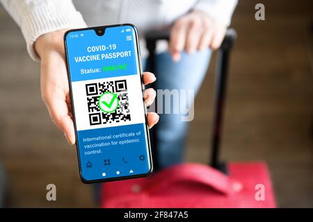 COVID-19 Impfpass im Mobiltelefon für die Reise hält Tourist Smartphone mit Gesundheitszertifikat App, digitalen Coronavirus-Pass. Konzept von c Stockfoto