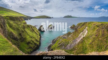 Wunderschönes Panorama von hohen Klippen, türkisfarbenem Wasser und Inseln am Dunquin Pier oder Hafen, Dingle, Wild Atlantic Way, Kerry, Irland Stockfoto