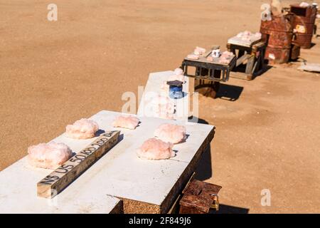 Tische an Ständen am Straßenrand, die Salzkristalle verkaufen, die in den Cape Cross Salzminen abgebaut und an Touristen, Cape Cross, Namibia, verkauft werden Stockfoto