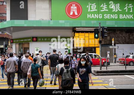 Hongkong, China. März 2021. Fußgänger werden gesehen, wie sie die Straße vor der Filiale der Hang Seng Bank in Hongkong überqueren. Kredit: Budrul Chukrut/SOPA Images/ZUMA Wire/Alamy Live Nachrichten Stockfoto