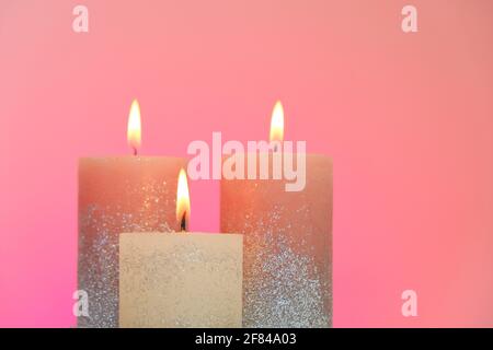Kerzen-Set. Festliche Glitzerkerzen auf rosa Hintergrund. Kerzenflamme. Stockfoto