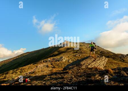 Ein junger Mann steigt von der Spitze des Berges Pip Ivan herab, beobachtet die epischen Landschaften rund um den Berg, trägt einen großen Wanderrucksack.2020 Stockfoto