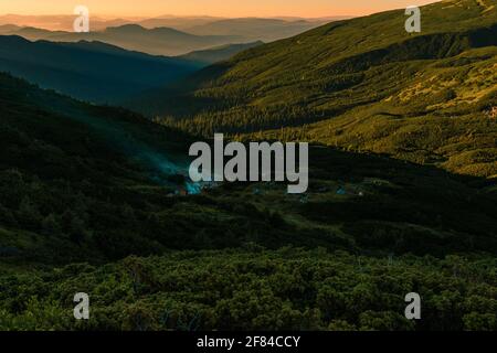 Sonnenaufgang in den Karpaten, auf dem Berg kann man am Horizont Zeltlager, Zelte in den Bergen, Camping in den Karpaten sehen.2020 Stockfoto