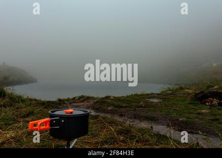 Gasflasche für Touristen, Gasheizung in der Nähe des Zeltes auf dem Hintergrund eines Bergsees.2020 Stockfoto