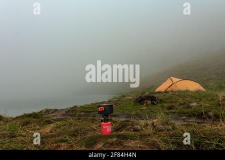 Gasflasche für Touristen, Gasheizung in der Nähe des Zeltes auf dem Hintergrund eines Bergsees.2020 Stockfoto