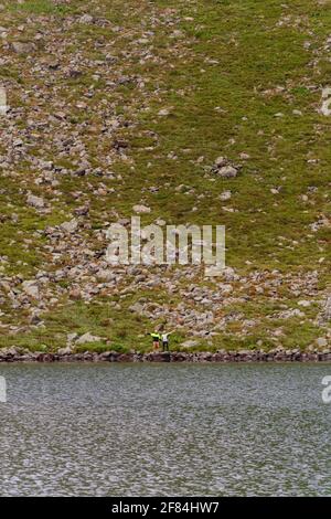 Ein paar Touristen stehen am Rande eines Bergsees, See Brebeneskul, der montenegrinischen Grat, die Karpaten von Ukraine,2020 Stockfoto