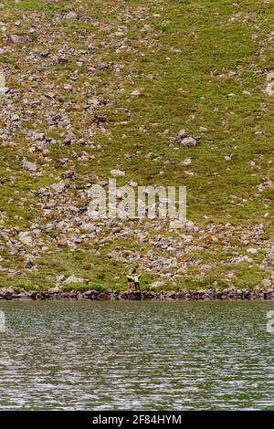 Ein paar Touristen stehen am Rande eines Bergsees, See Brebeneskul, der montenegrinischen Grat, die Karpaten von Ukraine,2020 Stockfoto