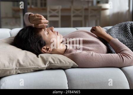 Junge lateinische Dame, die auf dem Rücken liegt und nach einem Nickerchen aufwacht Stockfoto