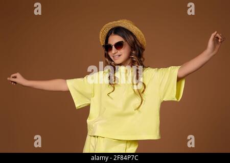 Nettes lockiges Mädchen in Hut und Sonnenbrille Stockfoto