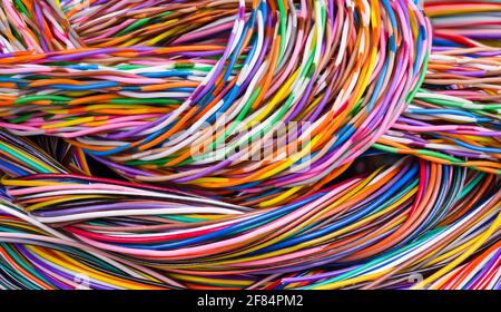 Bunte Hintergrund von mehradrigem Kabel Haufen. Nahaufnahme des Kabelgestänges. Schöne Zöpfe aus elektrischen Drähten in abstrakter Farbstruktur. Technik. Stockfoto