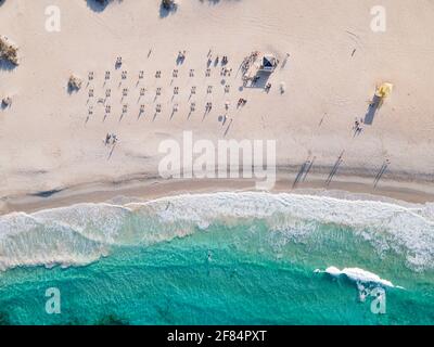 Sommerbild eines weißen Sandstrands mit Sonnenbaden und Surfen direkt von oben in Corralejo, Fuerteventura, Kanarische Inseln Stockfoto