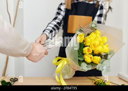 Frau Floristin verkauft Blumen an einen Mann Stockfoto