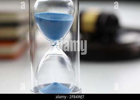 Nahaufnahme von Sanduhren mit blauem Sand im Inneren, die auf dem Tisch stehen Stockfoto