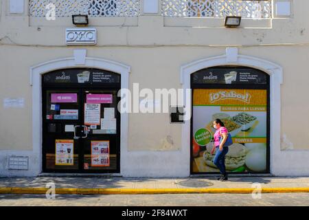 Frau mit Maske beim Spaziergang vor dem Oxxo-Geschäft in Merida, Mexiko - Pandemie Covid-19 Stockfoto