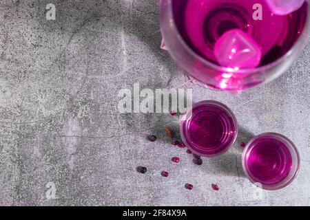 Rosafarbenes alkoholisches Getränk von oben mit Glaskelch und zwei Shot-Brille Stockfoto