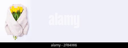 Blumenstrauß aus gelben Tulpen auf weißem Hintergrund Strickpullover, Draufsicht, Blumenstrauß aus gelben Tulpen für den Frauentag, Konzept der Frühlingsblumen. Stockfoto