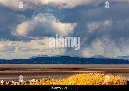 Heysham, Lancashire, Großbritannien. April 2021. Winterliche Duschen regnen auf den südlichen Lakeland Fells Credit: PN News/Alamy Live News Stockfoto