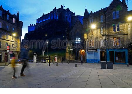 Edinburgh, Schottland, Großbritannien. April 2021. Das Edinburgh Castle ist vom Grassmarket aus in Blau beleuchtet. Im Rahmen des Welt-Parkinson-Tages werden Landmarken im ganzen Land blau leuchten, um ihre Unterstützung zu zeigen und das Bewusstsein für die Parkinson-Krankheit zu schärfen. Kredit: Craig Brown/Alamy Live Nachrichten Stockfoto