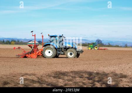 New Holland Traktor sät Getreideernte mit 1-Pass-Bohrer Unter einem blauen Himmel Stockfoto