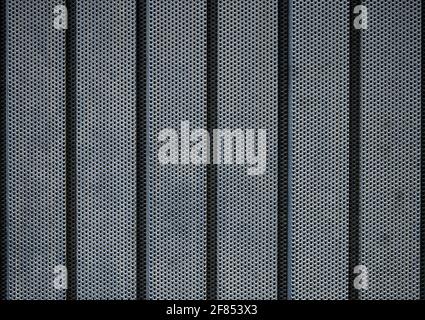 Detail eines Garagentor aus schwarzem Metall mit Löchern in IT Stockfoto