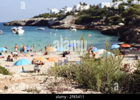 Sommerreise, Urlaubskonzept. Küste und Strandlandschaft. Verschwommener Hintergrund mit Meer, Booten und Schwimmern.Sonnenbaden Menschen, Touristen. Selektiv Stockfoto