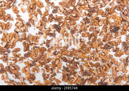 Geschälte, gehackte Hälften von Walnüssen in Haufen isoliert auf weißem Hintergrund. Stockfoto