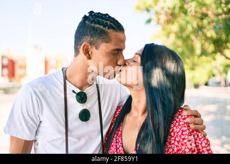 Junges lateinisches Paar, das auf der Straße der Stadt umarmt und küsst. Stockfoto