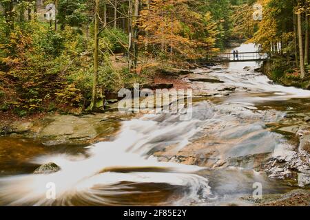 Herbstansicht des Flusses Mumlava und der Wasserfälle in der Nähe von Harrachov Stockfoto