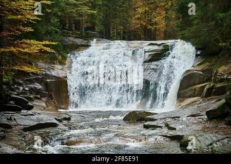 Herbstansicht des Flusses Mumlava und der Wasserfälle in der Nähe von Harrachov Stockfoto