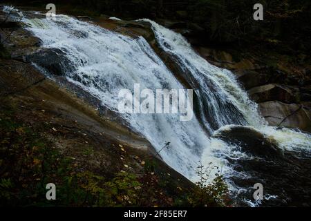 Herbstansicht des Flusses Mumlava und der Wasserfälle in der Nähe von Harrachov Stockfoto