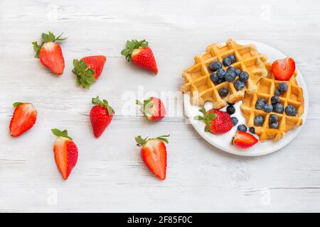 Hausgemachte belgische Waffeln mit Erdbeeren und Heidelbeeren. Köstliches Frühstück mit Beeren. Stockfoto