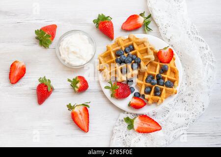 Hausgemachte belgische Waffeln mit Erdbeeren und Heidelbeeren. Köstliches Frühstück mit Beeren. Stockfoto