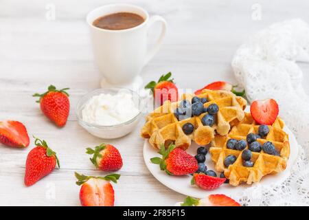 Hausgemachte belgische Waffeln mit Erdbeeren und Heidelbeeren. Köstliches Frühstück mit Beeren. Stockfoto