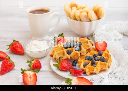 Hausgemachte belgische Waffeln mit Erdbeeren und Heidelbeeren. Köstliches Frühstück mit Beeren. Stockfoto